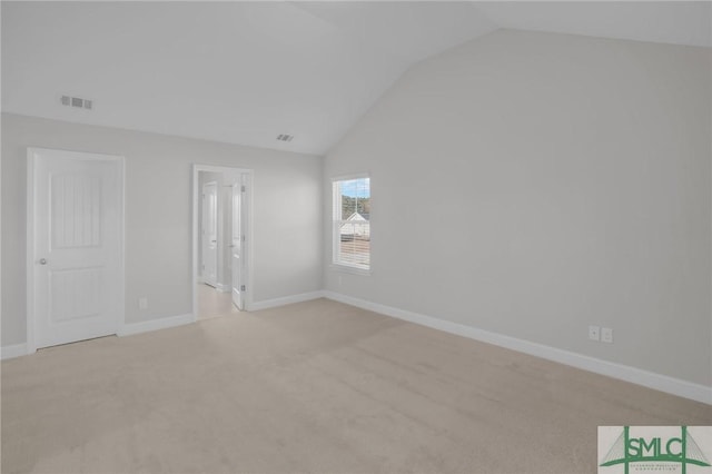 carpeted spare room with lofted ceiling