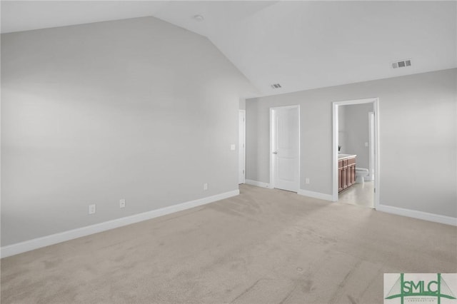 unfurnished room with vaulted ceiling and light carpet