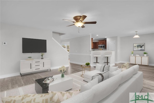 living room featuring ceiling fan and light hardwood / wood-style floors