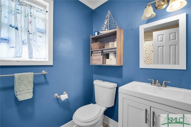 bathroom featuring toilet, vanity, crown molding, and a shower with curtain