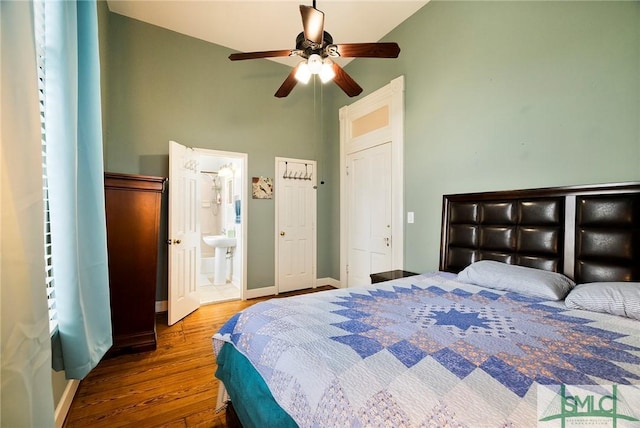 bedroom featuring ceiling fan, connected bathroom, lofted ceiling, and hardwood / wood-style floors