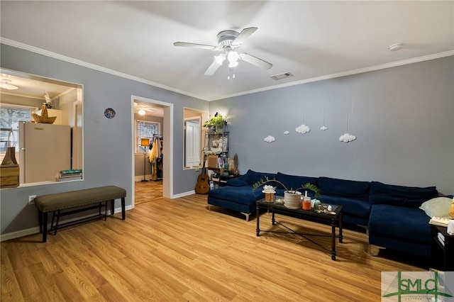 living room featuring ceiling fan, ornamental molding, and light hardwood / wood-style floors