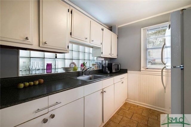 kitchen featuring white fridge, white cabinetry, and sink