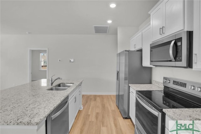 kitchen with white cabinetry, light hardwood / wood-style floors, a center island with sink, appliances with stainless steel finishes, and sink