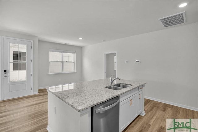 kitchen with light hardwood / wood-style flooring, a center island with sink, dishwasher, white cabinets, and sink