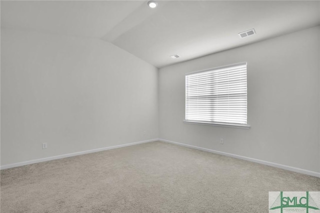 carpeted spare room featuring lofted ceiling