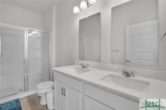 bathroom featuring an enclosed shower, vanity, toilet, and hardwood / wood-style floors