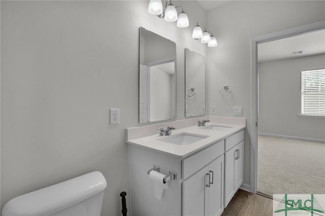 bathroom featuring toilet, vanity, and a chandelier