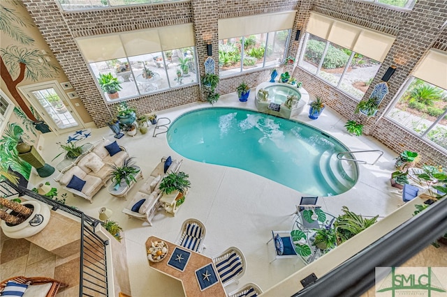 view of swimming pool featuring an indoor hot tub