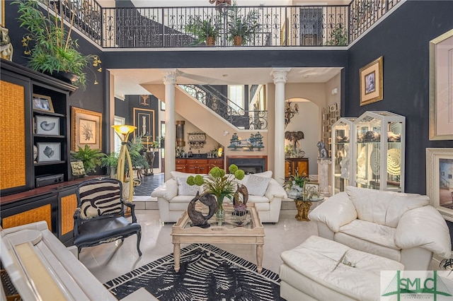 living area with a high ceiling and ornate columns