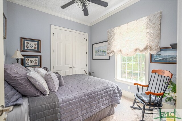 carpeted bedroom with a closet, crown molding, a textured ceiling, and ceiling fan