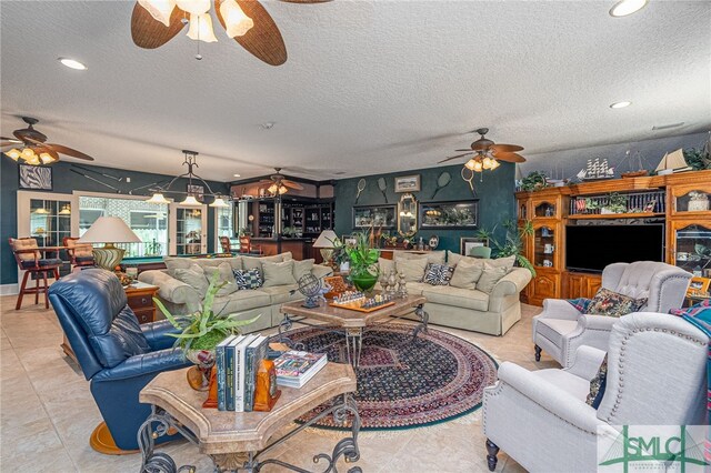 living area featuring recessed lighting, ceiling fan, a textured ceiling, and light tile patterned floors