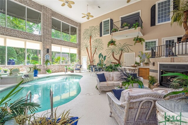 outdoor pool with ceiling fan, a patio area, and an outdoor living space