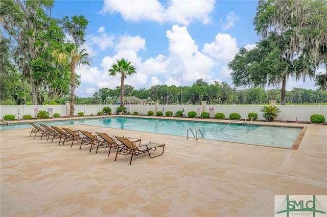 community pool featuring fence and a patio