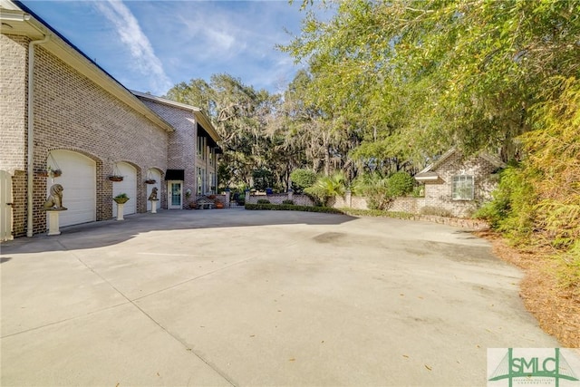 view of home's exterior featuring driveway and brick siding