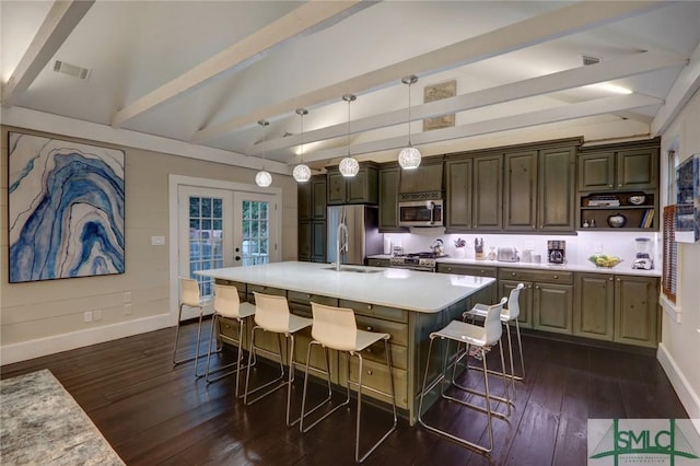 kitchen with a kitchen breakfast bar, hanging light fixtures, french doors, a kitchen island with sink, and stainless steel appliances