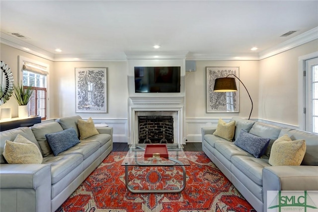 living room with hardwood / wood-style floors, plenty of natural light, and ornamental molding