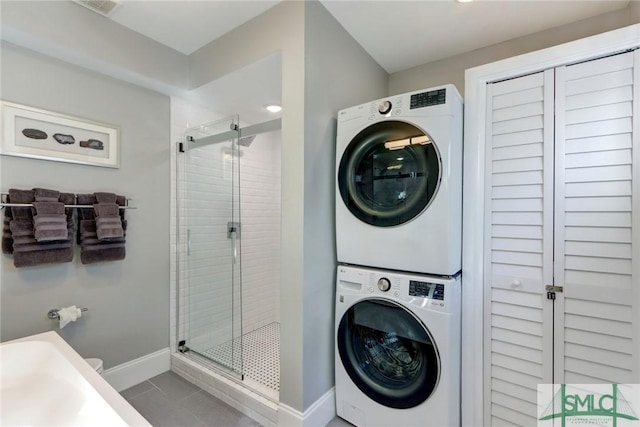 washroom with stacked washer and clothes dryer and tile patterned floors