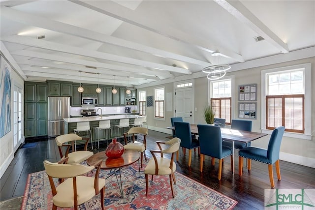 dining space featuring sink, a chandelier, dark hardwood / wood-style floors, and beamed ceiling