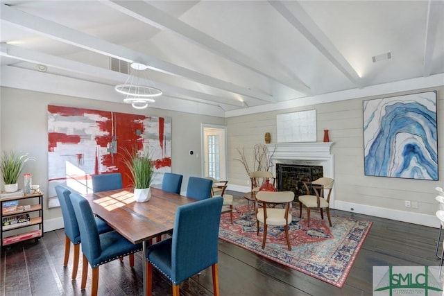 dining area with beamed ceiling, an inviting chandelier, a fireplace, and dark hardwood / wood-style flooring