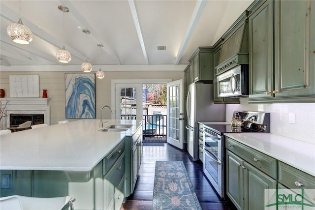 kitchen featuring sink, green cabinets, beam ceiling, and stainless steel appliances