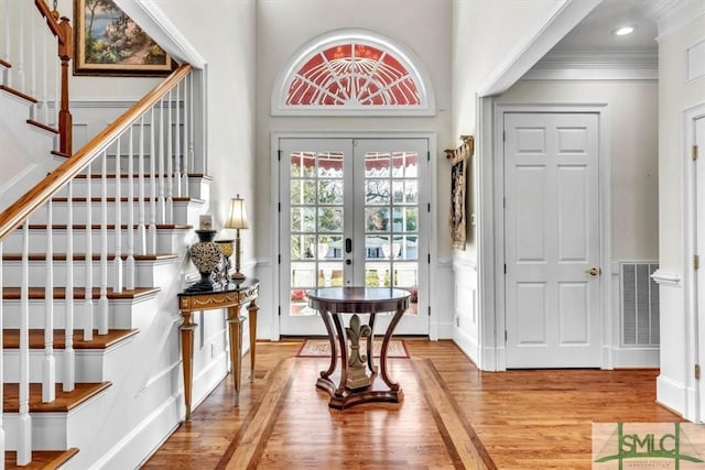 entryway featuring french doors, ornamental molding, and light hardwood / wood-style flooring