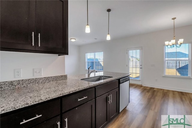 kitchen featuring hardwood / wood-style floors, dishwasher, sink, dark brown cabinets, and light stone counters