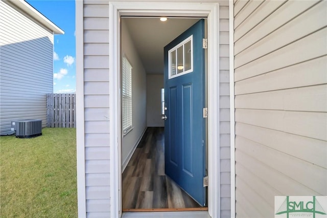 property entrance featuring central AC unit and a yard