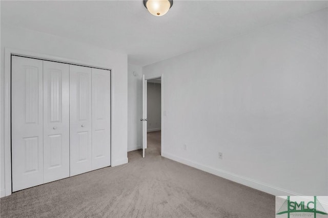 unfurnished bedroom with a closet and light carpet