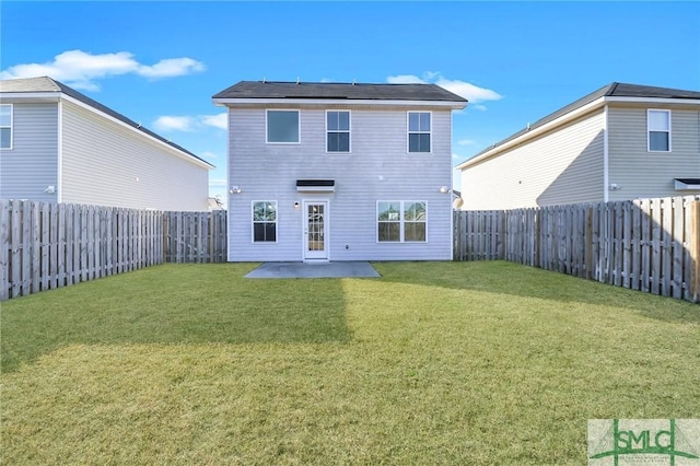 back of house with a lawn and a patio