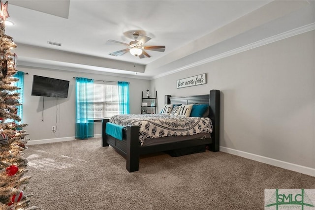 bedroom featuring ceiling fan, a raised ceiling, crown molding, and carpet floors