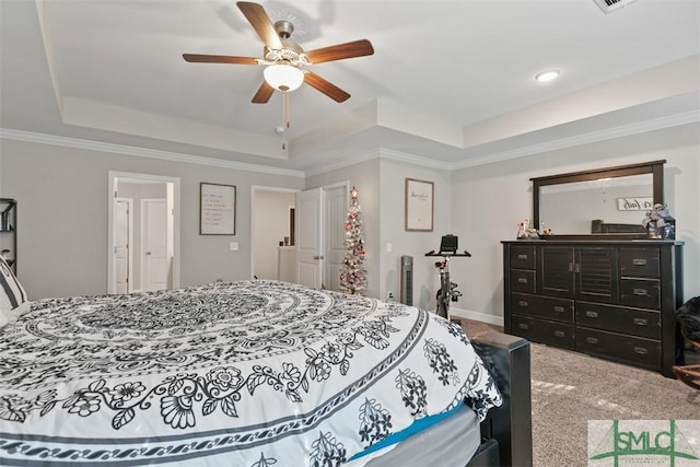 bedroom featuring ceiling fan, carpet, a tray ceiling, and ornamental molding