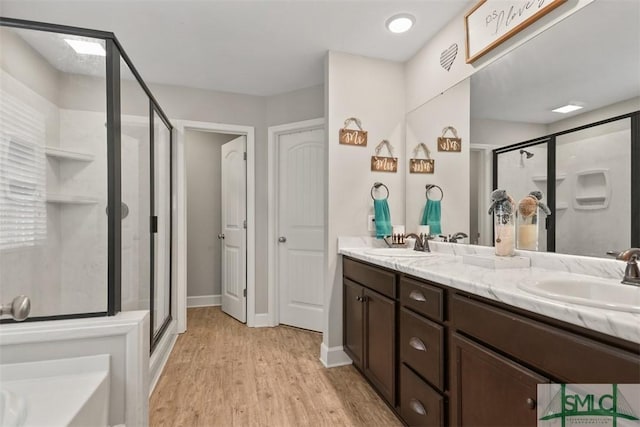 bathroom with vanity, hardwood / wood-style floors, and a shower with door