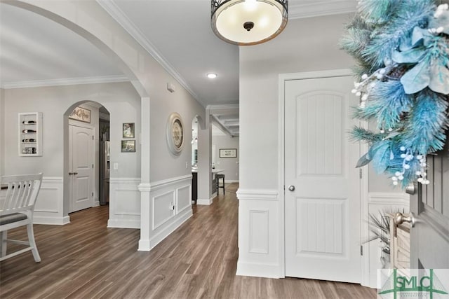 foyer with wood-type flooring and ornamental molding