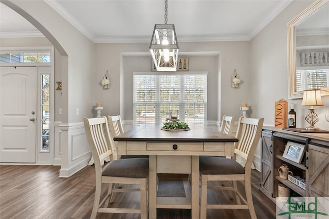 dining area featuring dark wood-type flooring, plenty of natural light, and crown molding