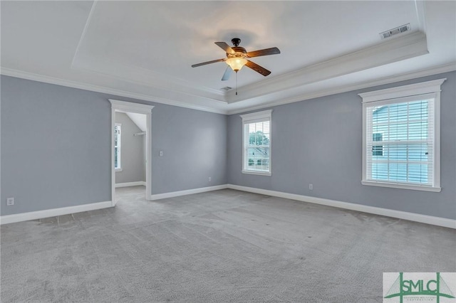 carpeted empty room featuring ceiling fan, a tray ceiling, and ornamental molding