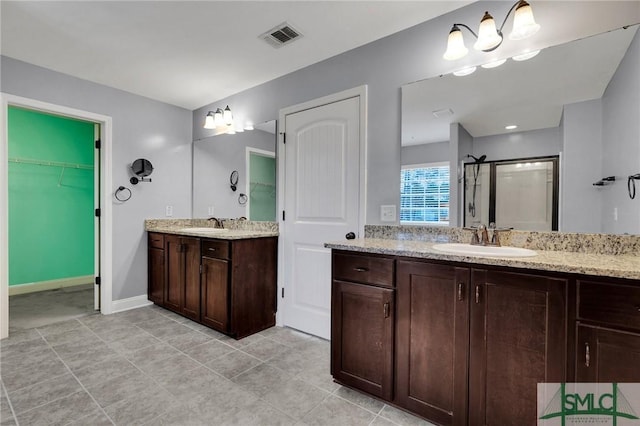 bathroom with a shower with door and vanity