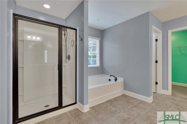 bathroom with tile patterned floors and shower with separate bathtub