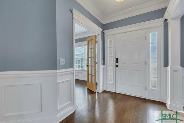 foyer entrance with decorative columns, dark hardwood / wood-style flooring, and ornamental molding