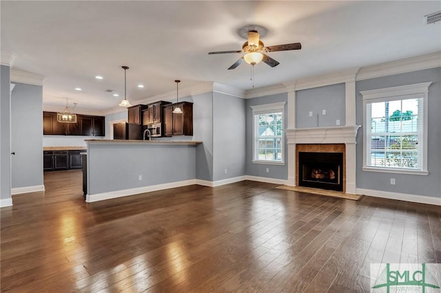 unfurnished living room featuring dark hardwood / wood-style flooring, crown molding, and a tile fireplace