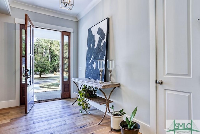 entrance foyer featuring crown molding and light hardwood / wood-style flooring