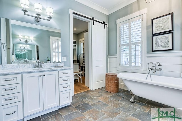 bathroom with crown molding, vanity, and a bath