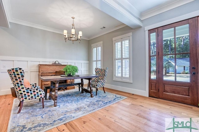 dining space with crown molding, a notable chandelier, beam ceiling, and light wood-type flooring