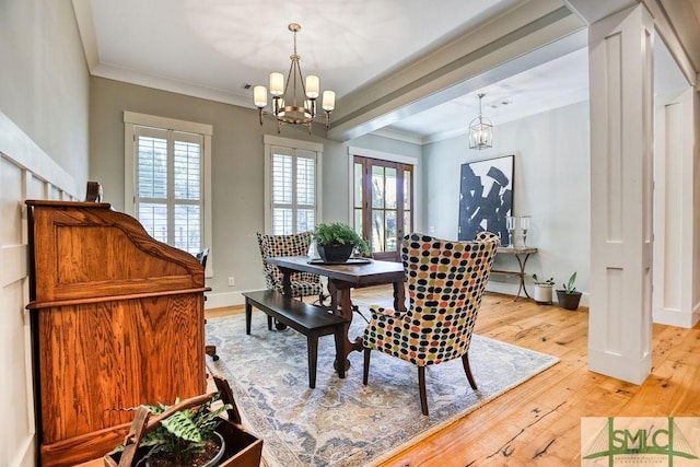 dining area with ornamental molding, a chandelier, and light wood-type flooring