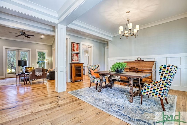 dining room with beam ceiling, crown molding, ceiling fan with notable chandelier, and light wood-type flooring