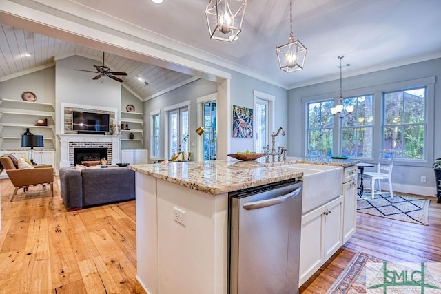 kitchen featuring built in features, dishwasher, white cabinetry, an island with sink, and decorative light fixtures