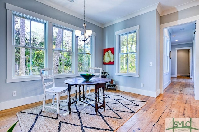 dining area with light hardwood / wood-style flooring, ornamental molding, and a chandelier