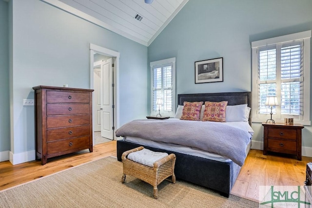 bedroom featuring vaulted ceiling, light hardwood / wood-style floors, multiple windows, and wooden ceiling