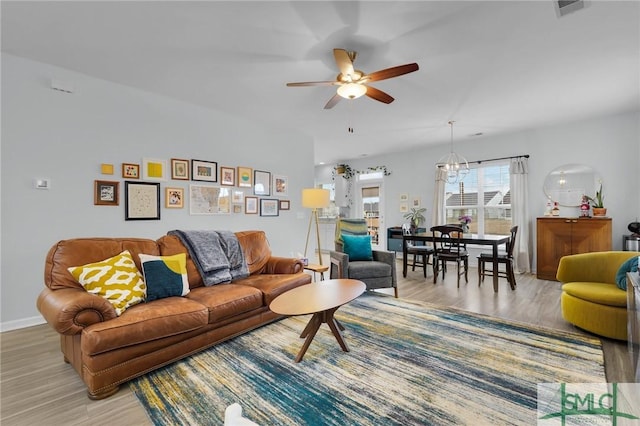 living room featuring hardwood / wood-style flooring and ceiling fan with notable chandelier