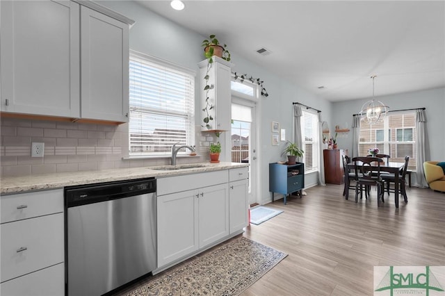 kitchen with sink, stainless steel dishwasher, white cabinets, and light hardwood / wood-style flooring